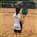Jogadora de beach tennis em quadra de areia com a raquete Optum Flex